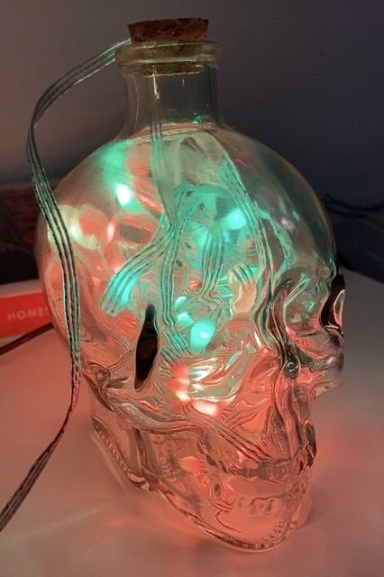 Photo of a clear glass skull shaped bottled stuffed full of multicoloured LEDs